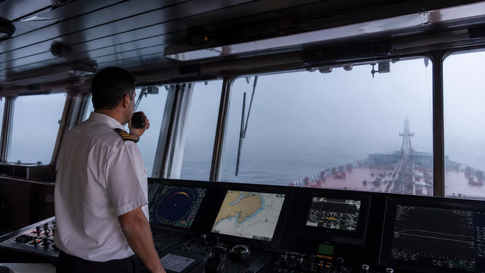 Gemi siren kodları ve düdük işaretlerini öğrenen denizcilik öğrencileri köprüüstünde sisli havada COLREG ses işaretlerini inceliyor.